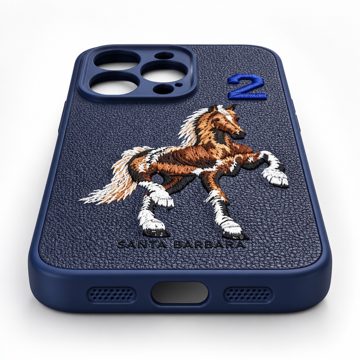 Navy blue iPhone 15 Pro embroidered horse case close-up showing the bottom port and speaker cutouts