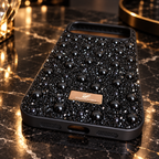 Close-up of the bottom edge and port cutouts on the black iPhone 17 Pro Max rhinestone and pearl case