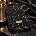 Black pearl and rhinestone-style fashion phone case on dark marble